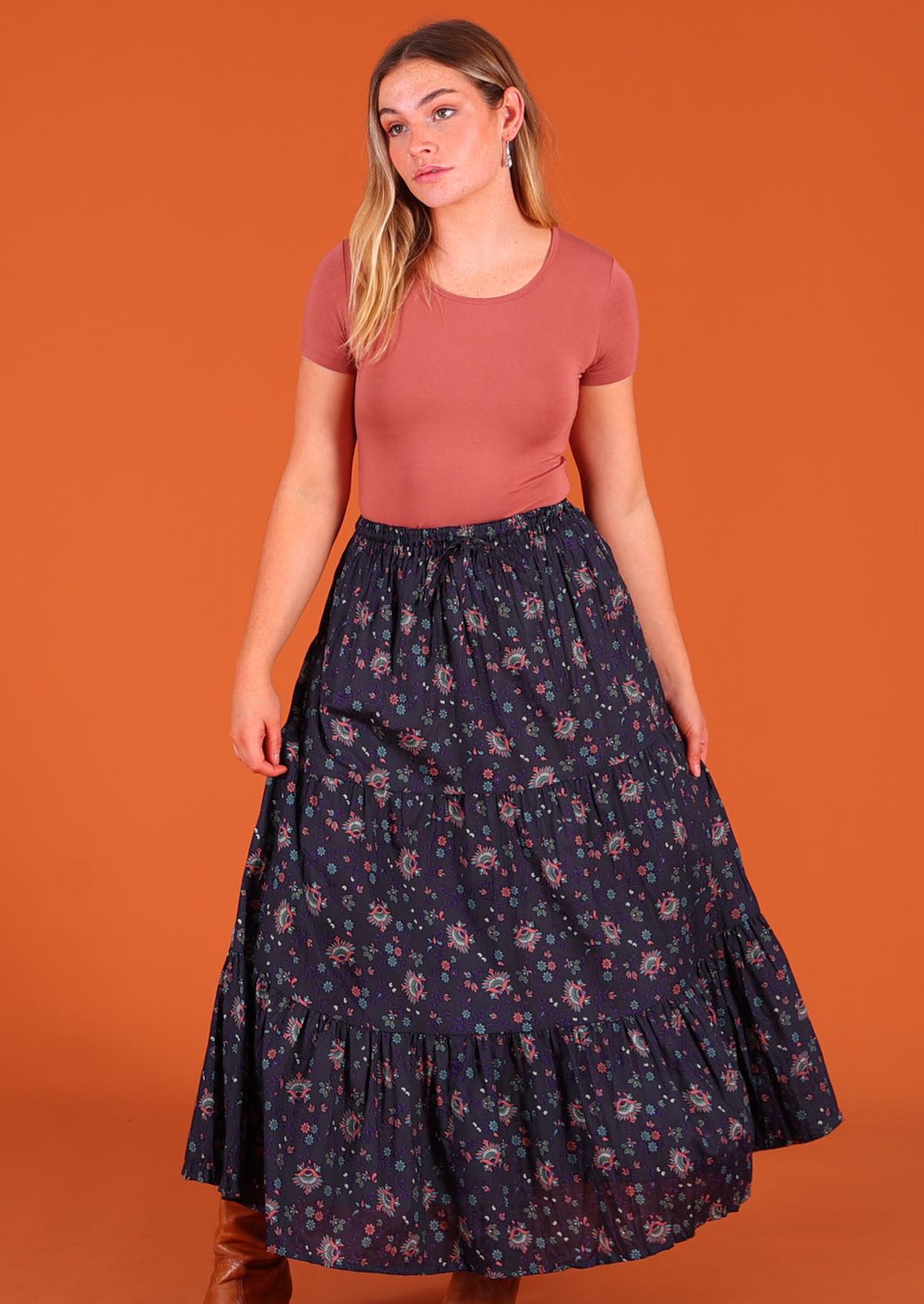 Model standing wearing dark Purple 100 percent cotton Indian floral printed three tiered maxi skirt