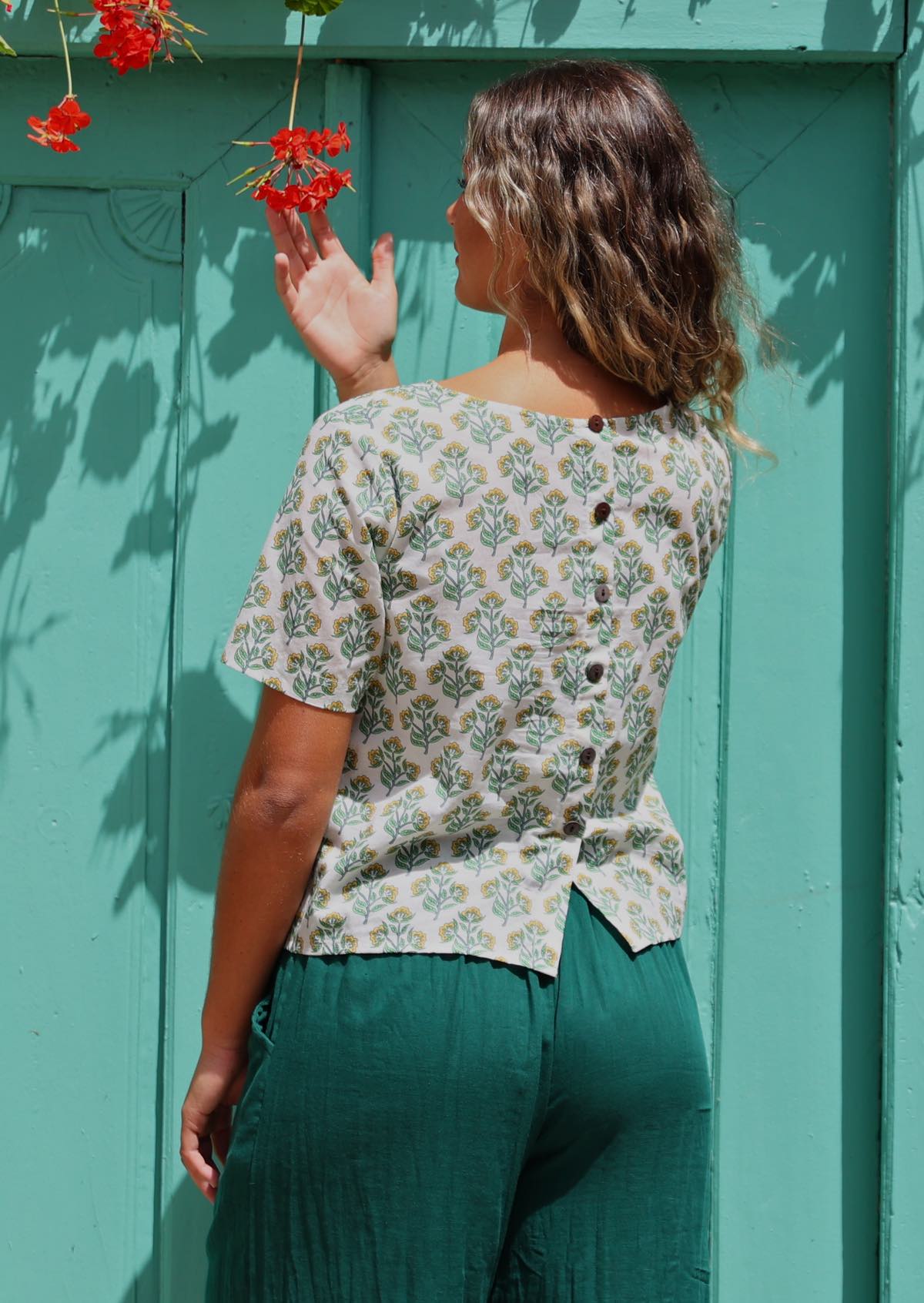 woman in loose fit white cotton boxy blouse buttons down back