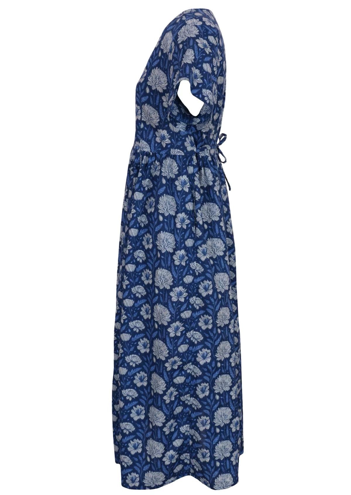 100 percent cotton navy blue button through v-neck dress with pockets and shoestring tie at the back. Side view of dress