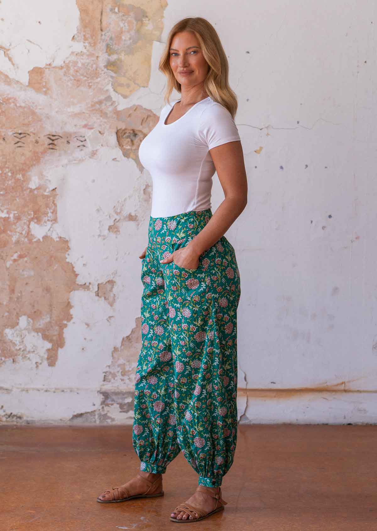 Model poses in 100% cotton floral harem pants with wide waistband and pockets