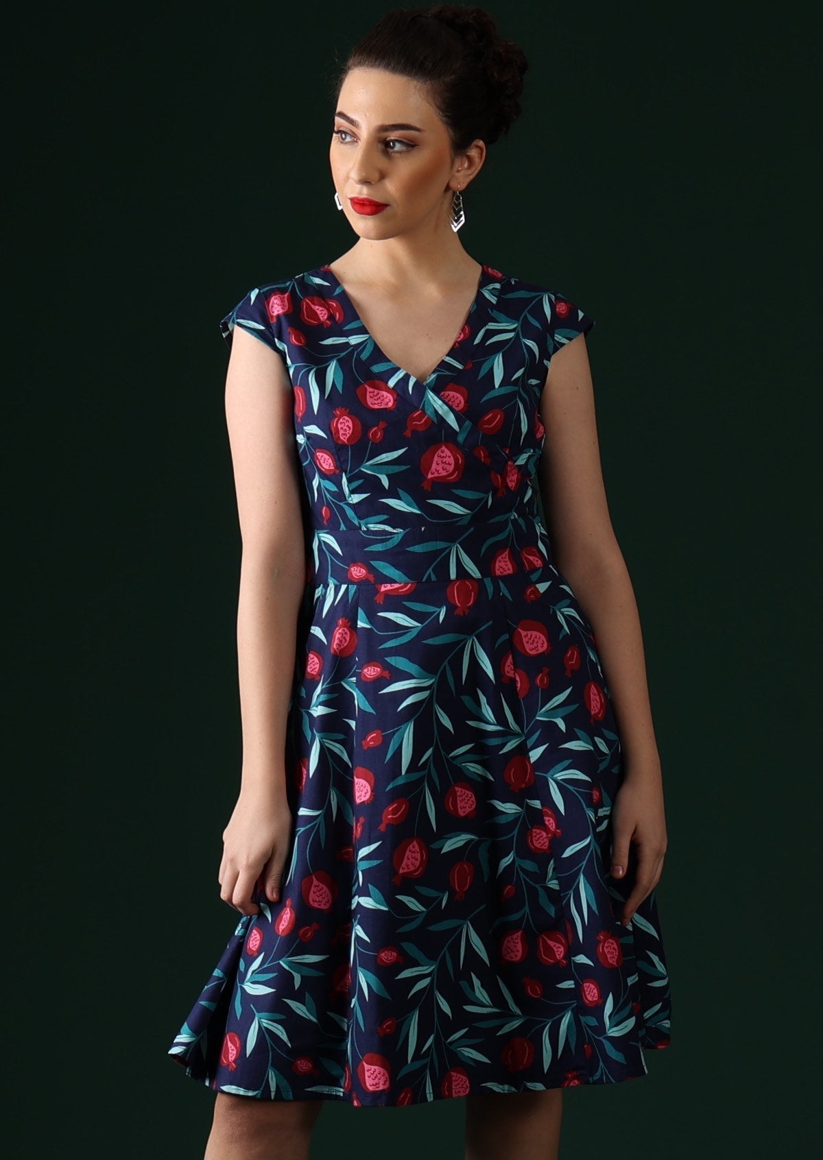 Model wears retro dress with cap sleeves.