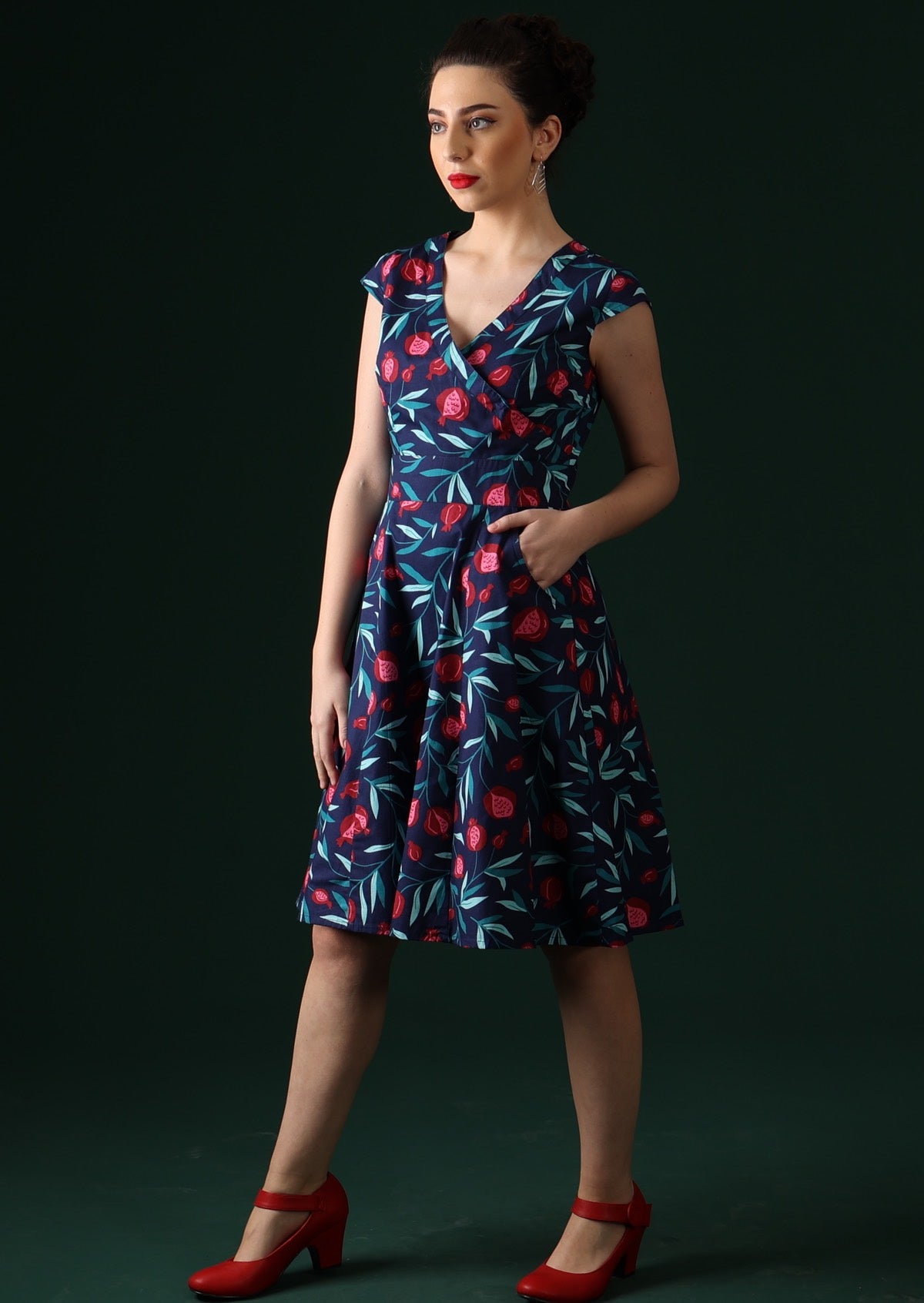 Model wears knee length dress with pockets.