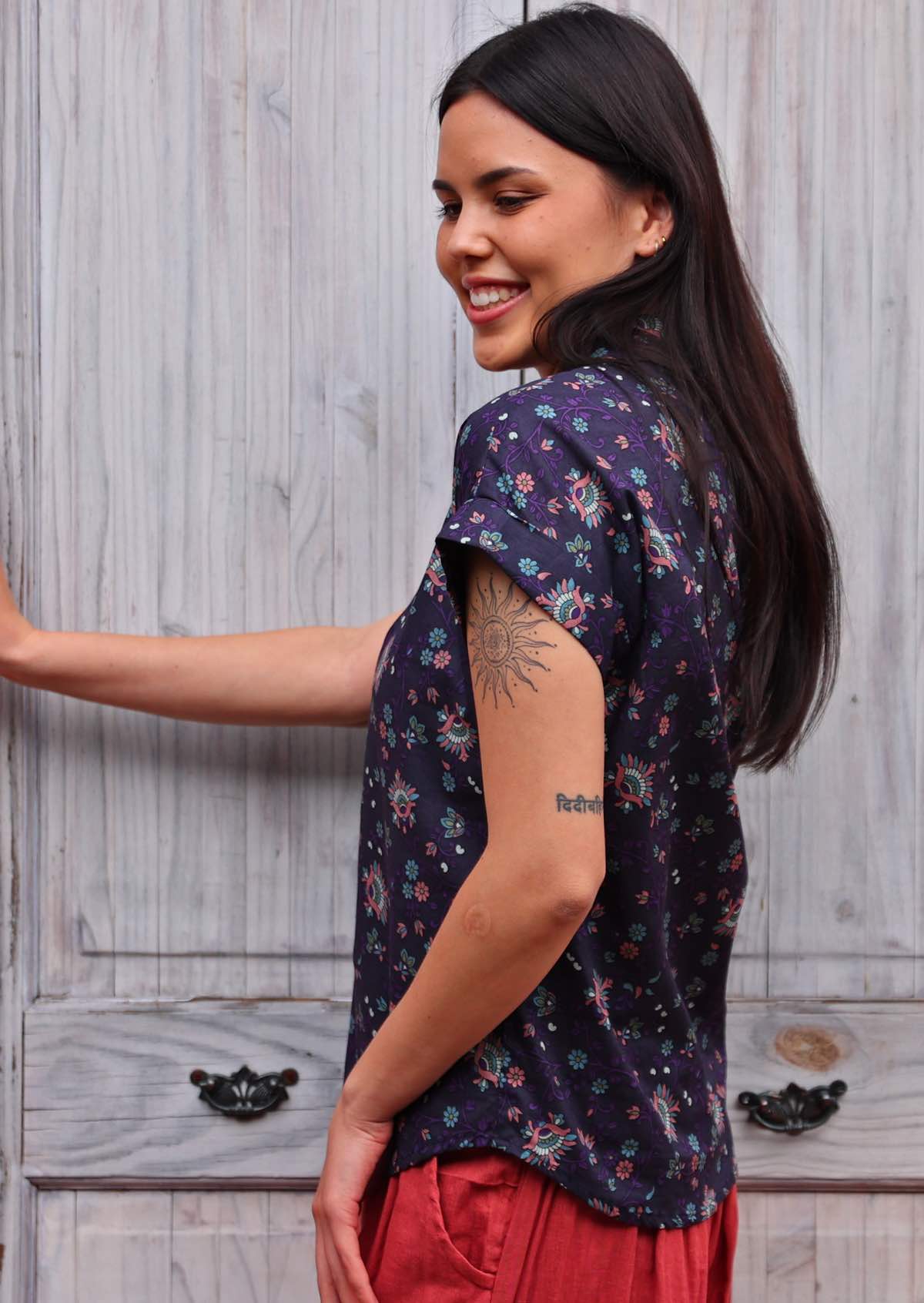 side view of woman with dark hair in cotton blouse with shirt collar in Indian print 