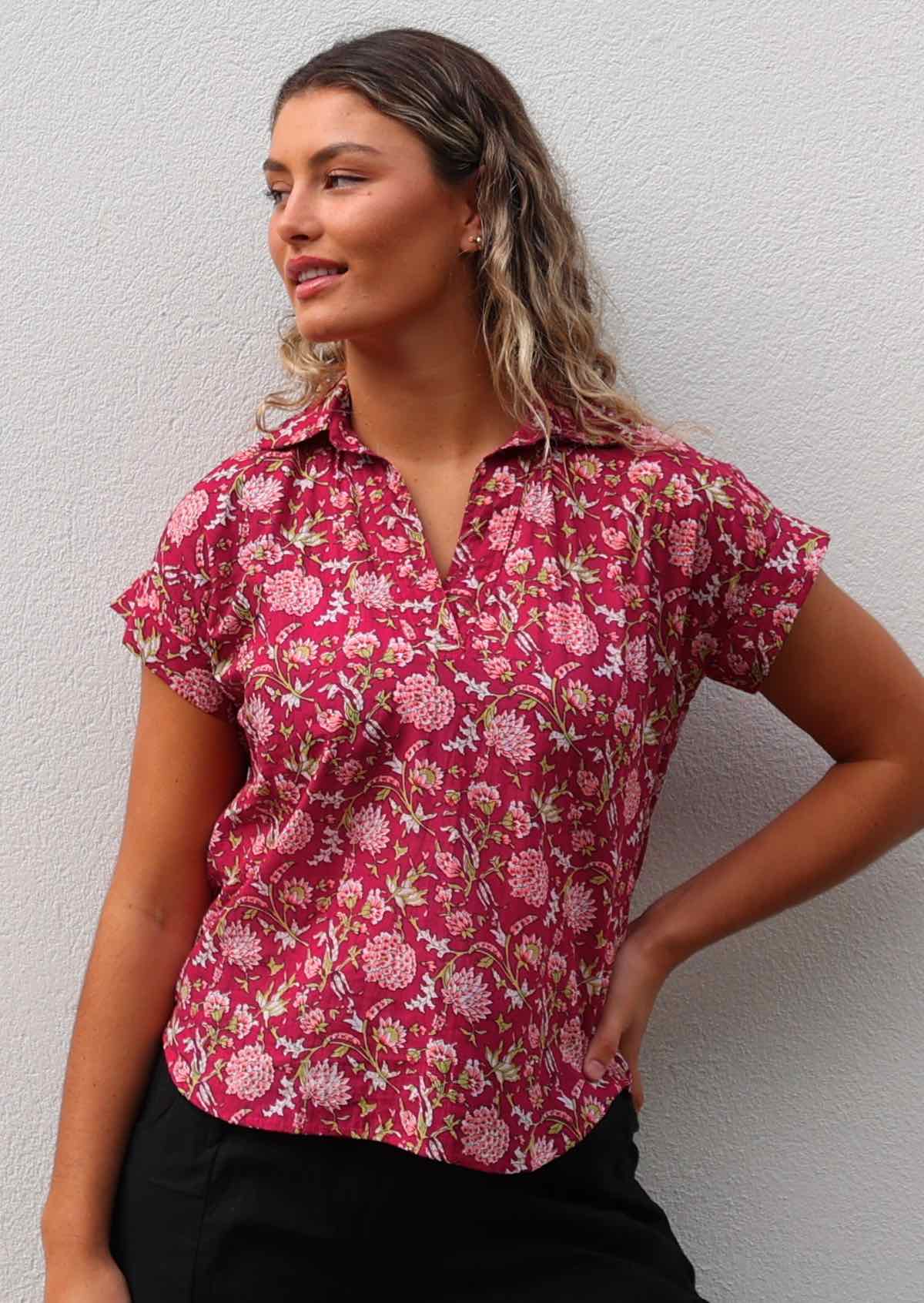 Woman wears cotton relaxed fit short sleeve shirt with rolled cuff in floral print