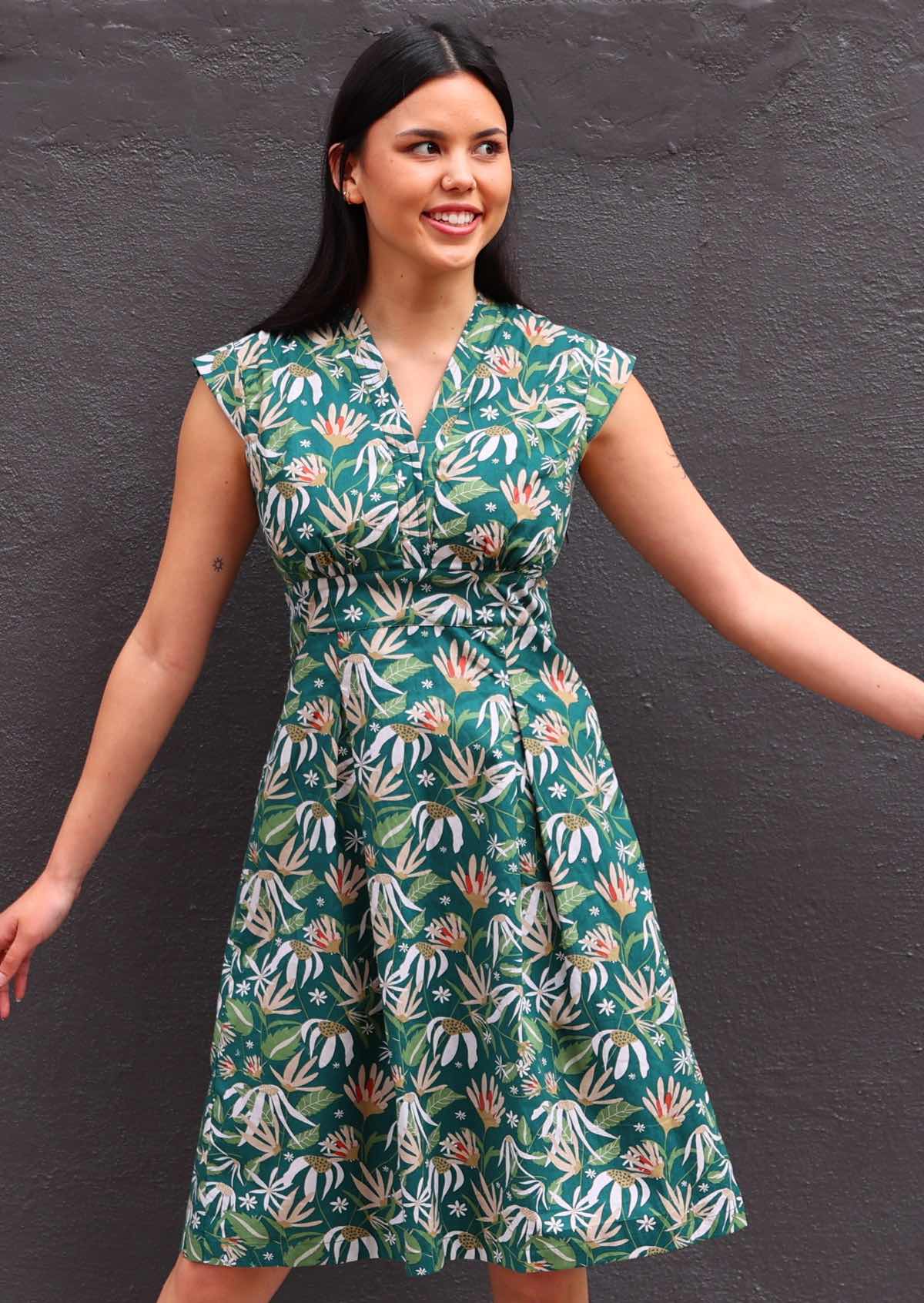 Model wearing floral dress with dark green background 100 percent cotton retro style 