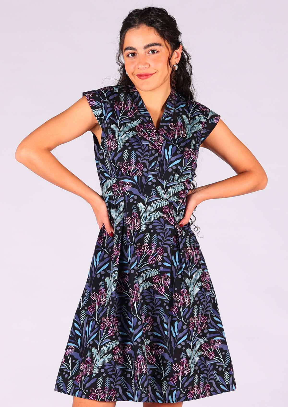 Model wears sweet retro cotton dress with blue and pink floral print on black base