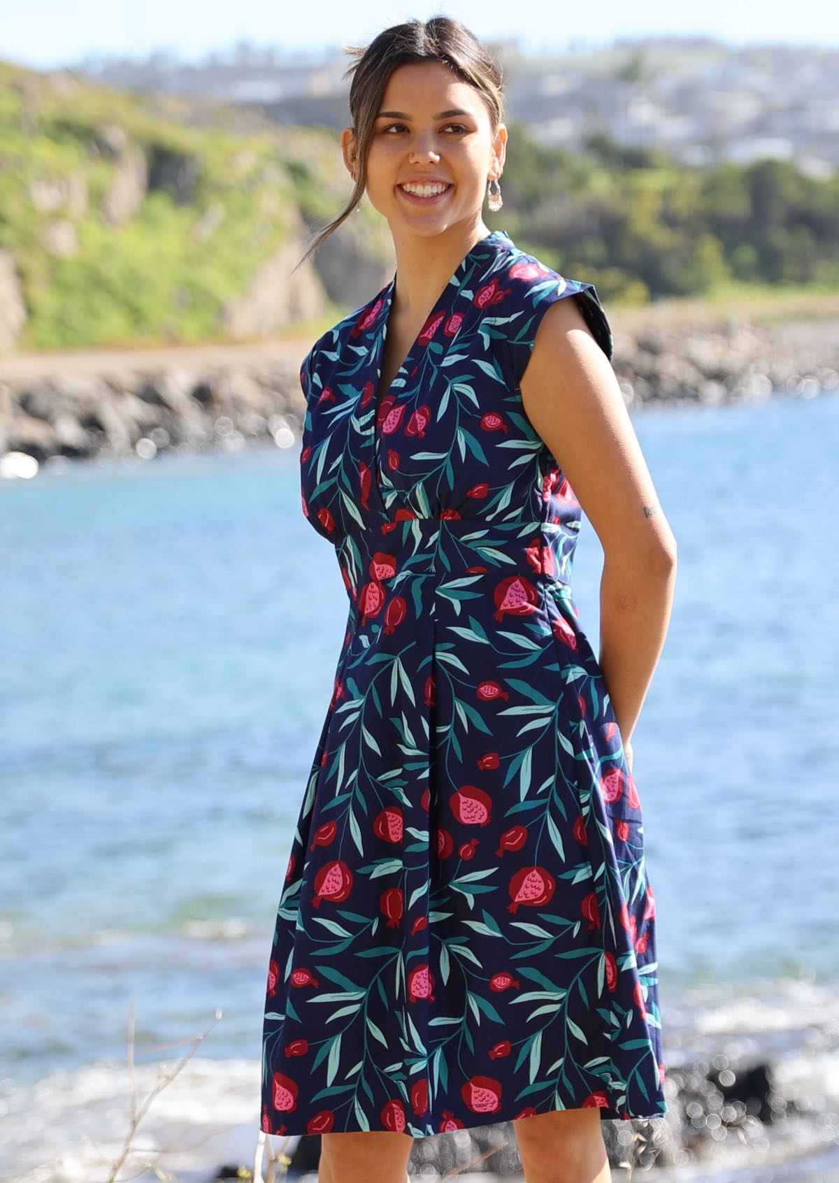 Women wears fruit print dress with cap sleeves.