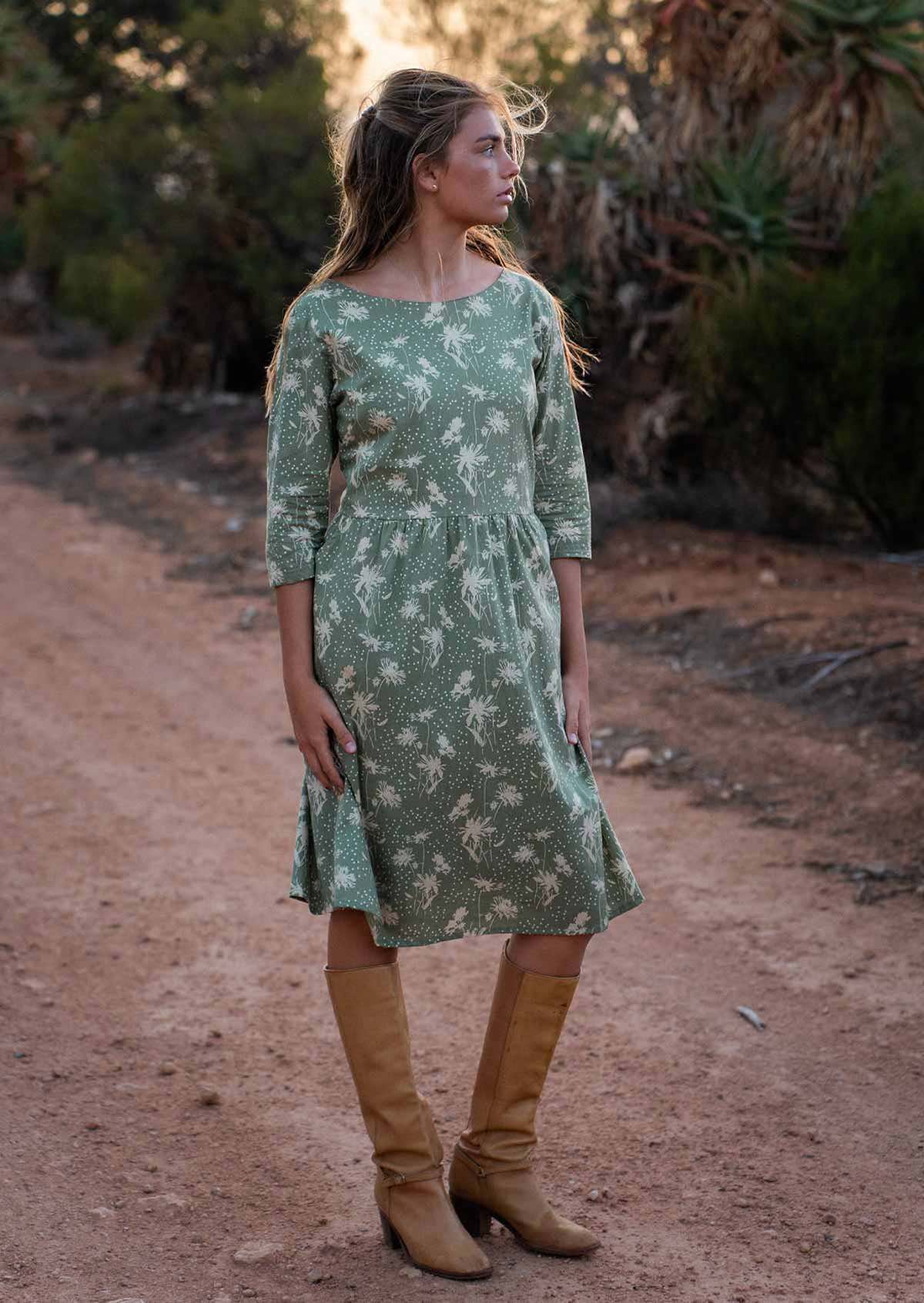 Model wears cotton 3/4 sleeve over the knee length dress in pale green with cream floral silhouette print