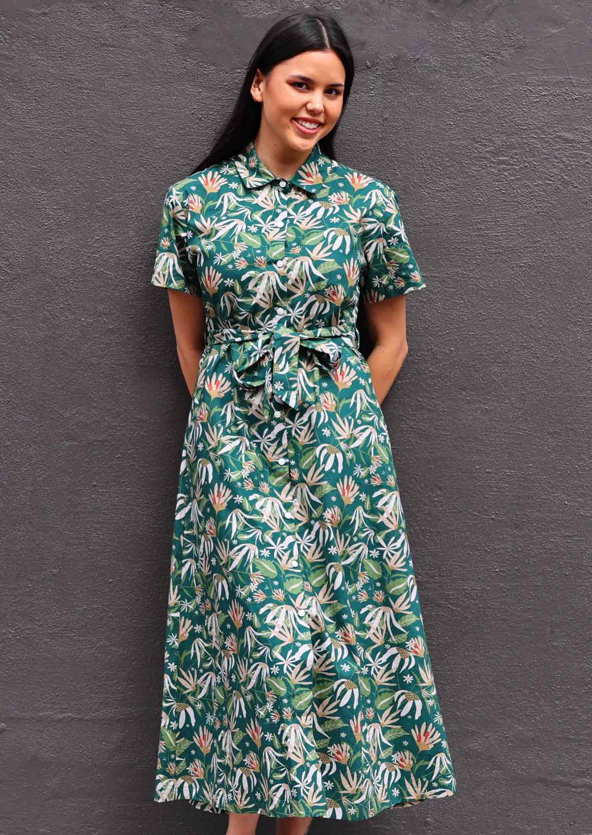 Woman with dark hair wearing 100% cotton green floral shirt dress, button up front