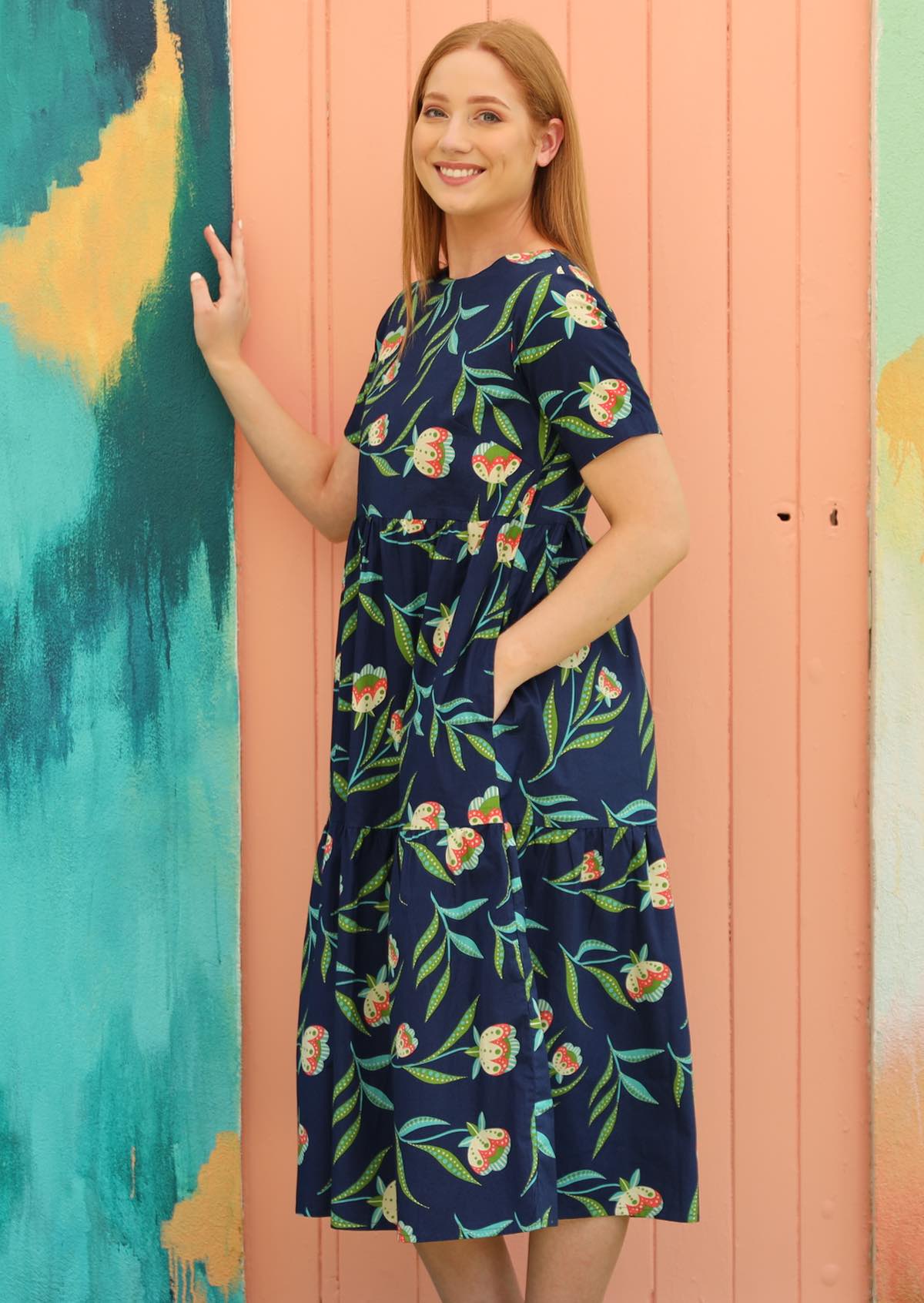 Model wears navy blue cotton dress with high round neckline