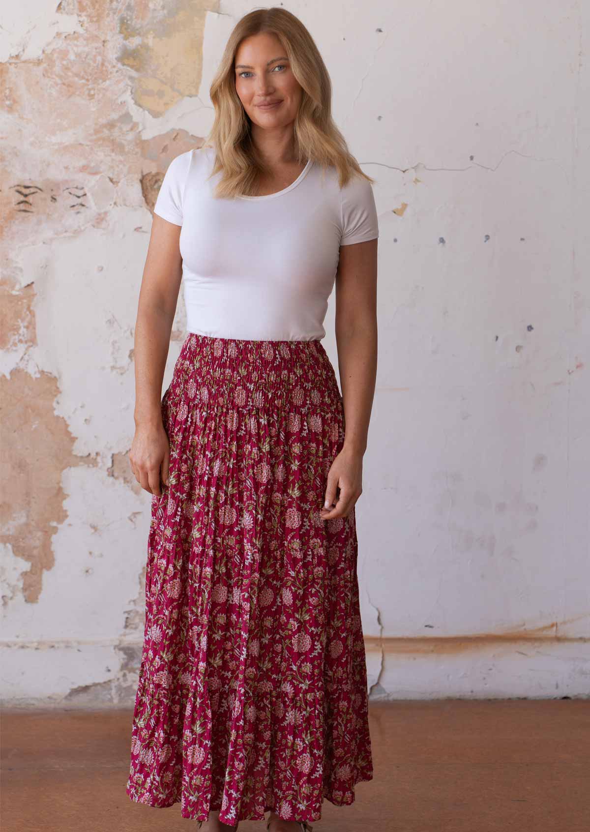 Model wears cotton maxi skirt with wide elastic shirred waistband, in floral print on bright red base