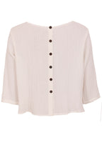 Back mannequin photo of natural white double cotton 3/4 sleeve top with decorative buttons down centre back