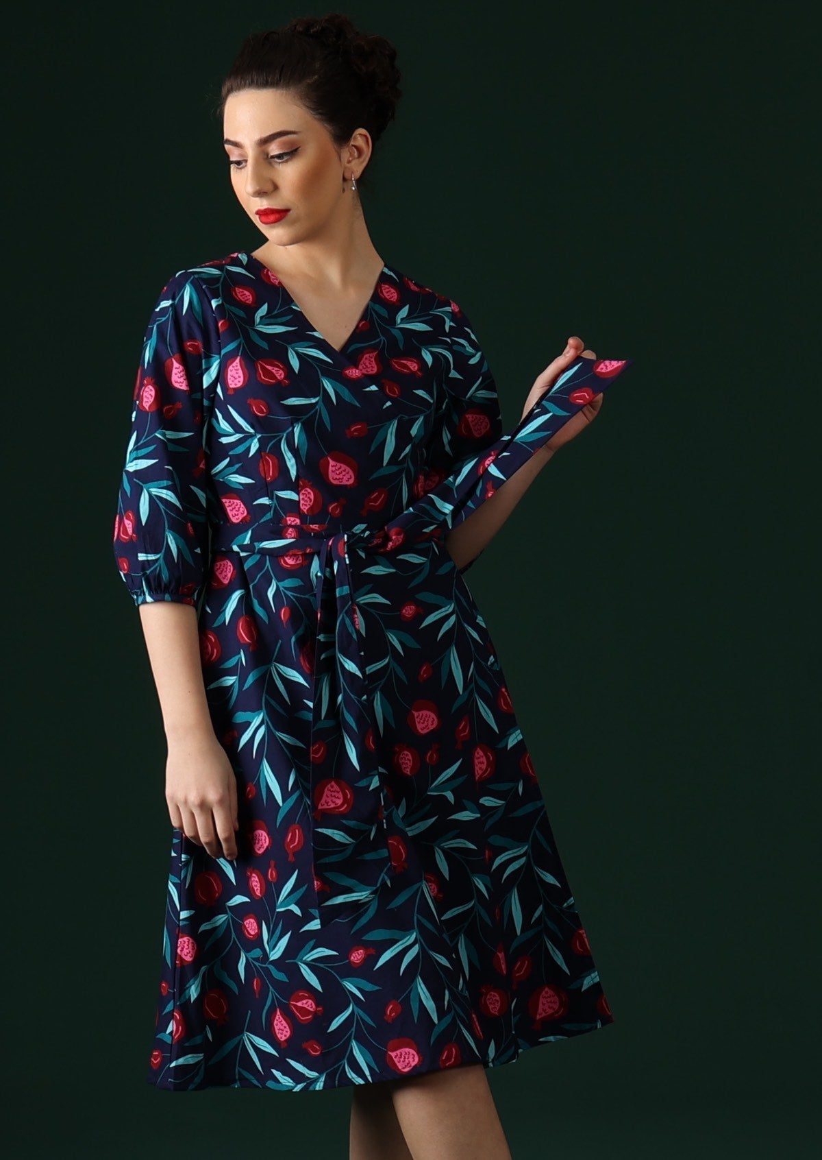 Model wears wrap dress with thick waist tie.