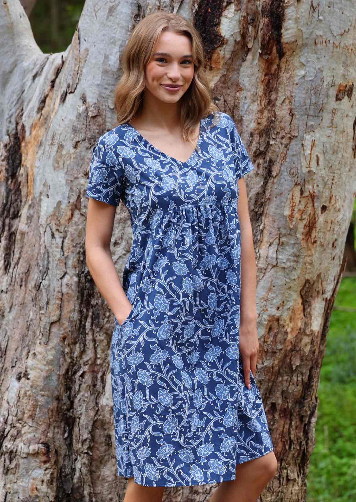 Model with one hand in pocket standing wearing the Etta Dress Neela cotton sundress with short sleeves 