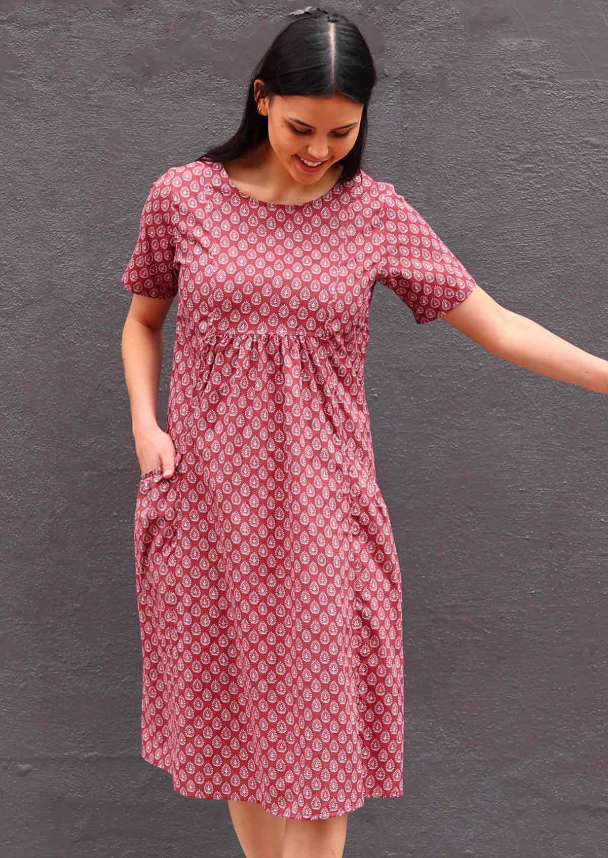 Model with her hand in pocket looking down wearing short sleeve cotton sundress