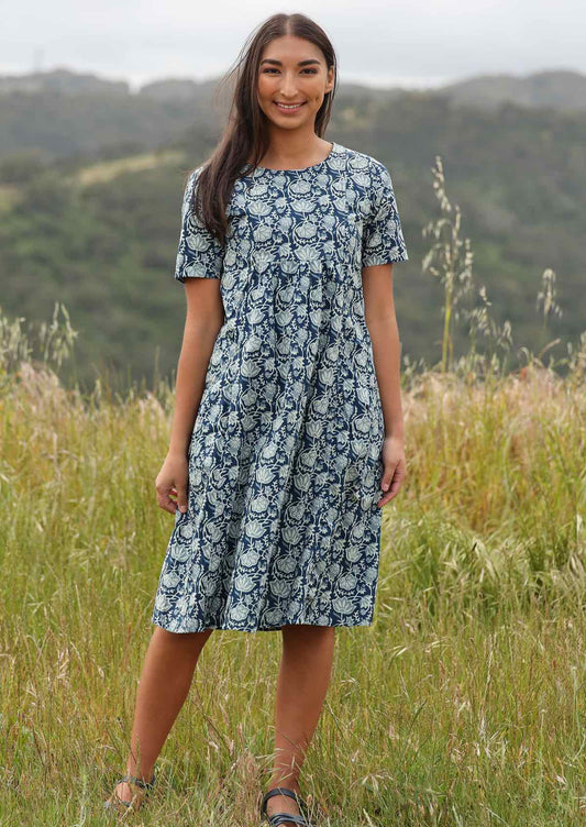 Woman styles blue based dress with sandals. 