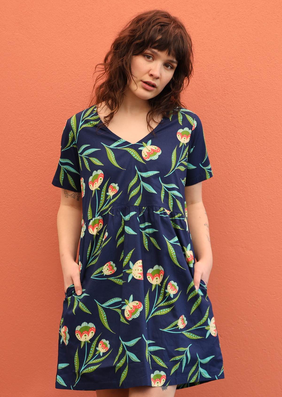 Model wears loose fitting dress. 