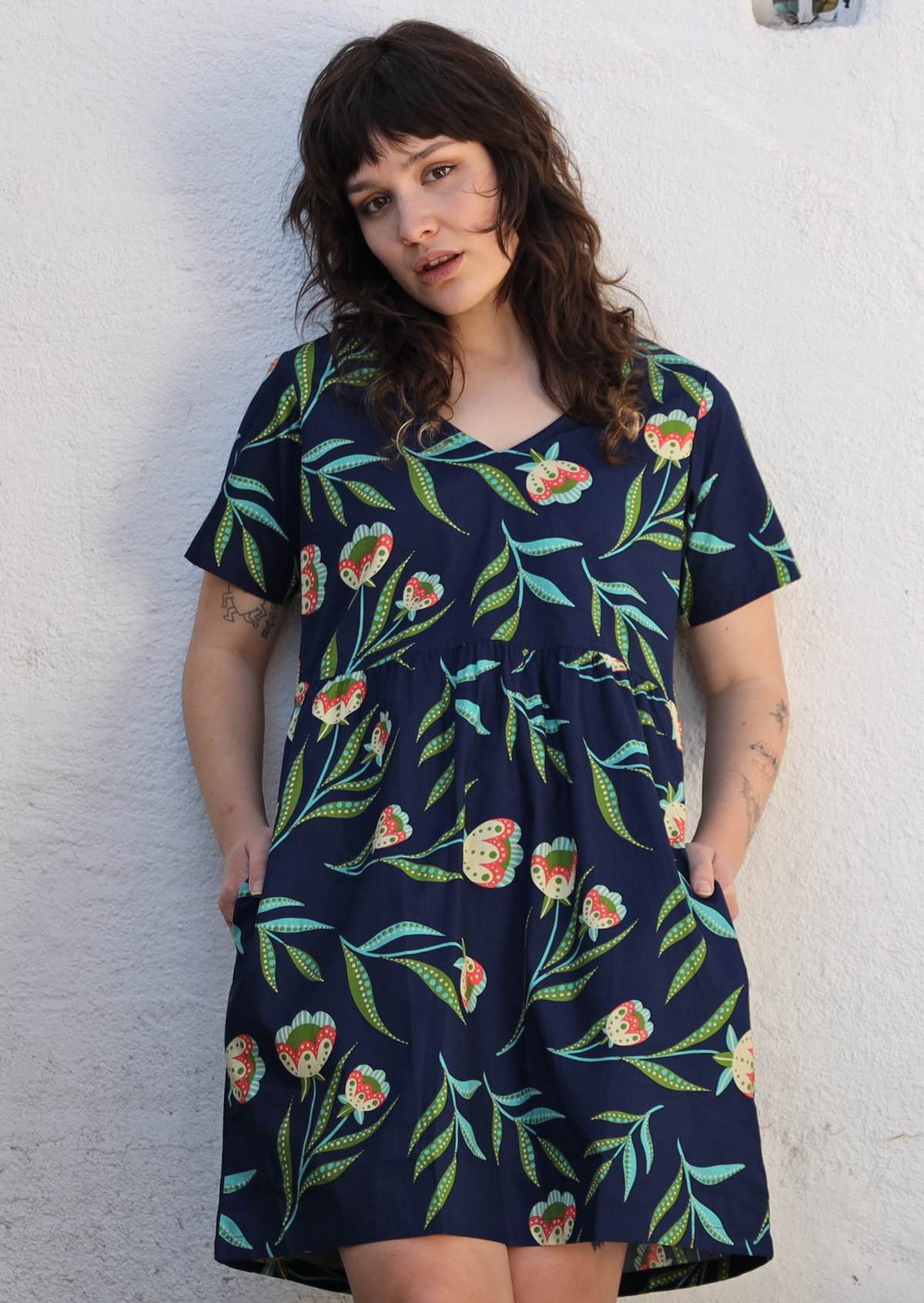 Model wears Blue Floral V-Neck dress with hidden side pockets. 