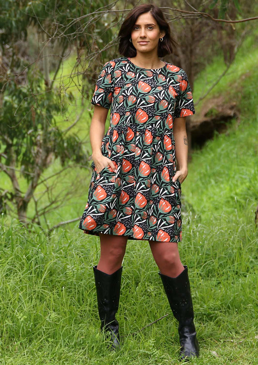 Model wears 100% cotton short sleeve relaxed fit dress with hidden side pockets in botanical print