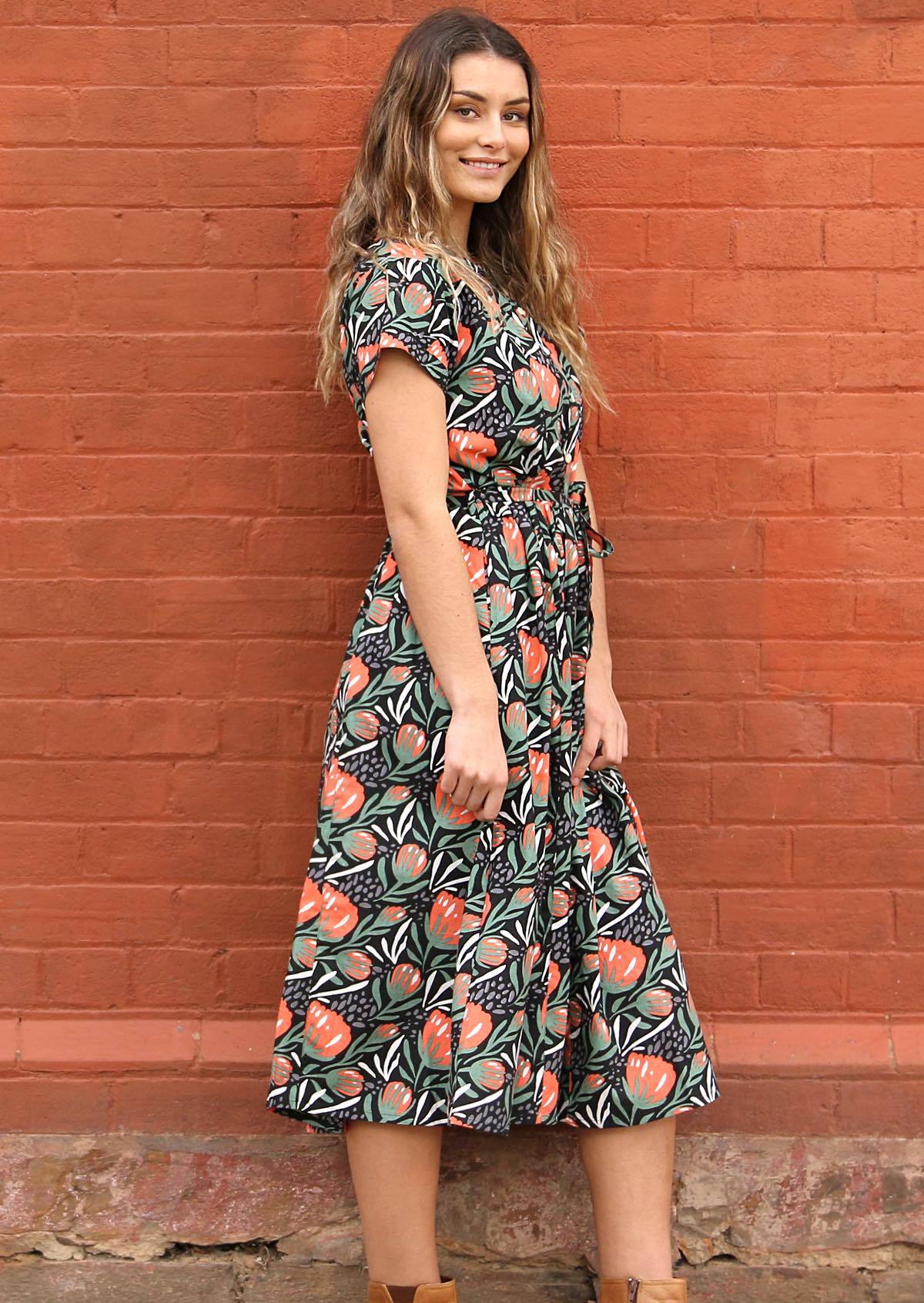 Midi length cotton dress in botanical print of green, grey, red and white on black base