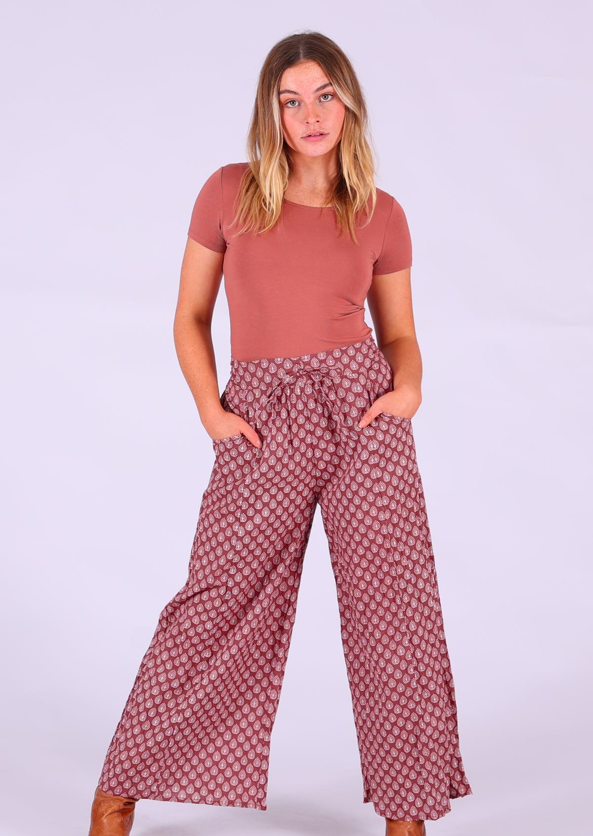 Model wearing Janis Pant Henna 100 percent cotton wide legged women's palazzo with hands in pockets