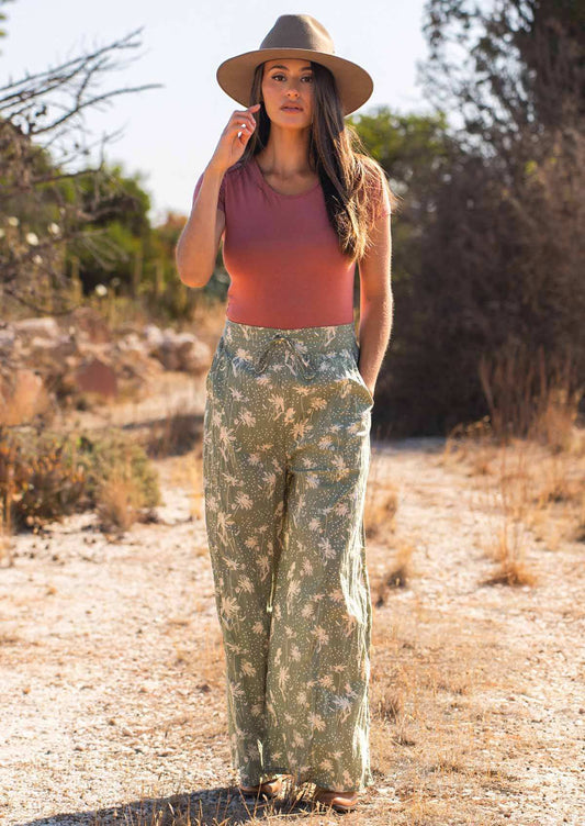 Model wears wide leg cotton high waisted pants with drawstring and hand in deep pocket