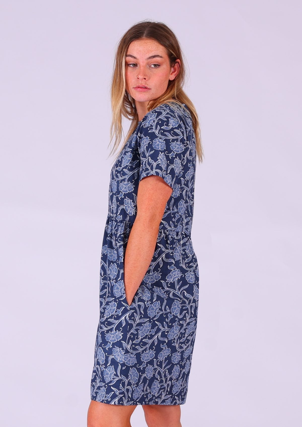 Model standing sideways with hand in pocket wearing Mabel Dress Neela 100 percent cotton women's dress 