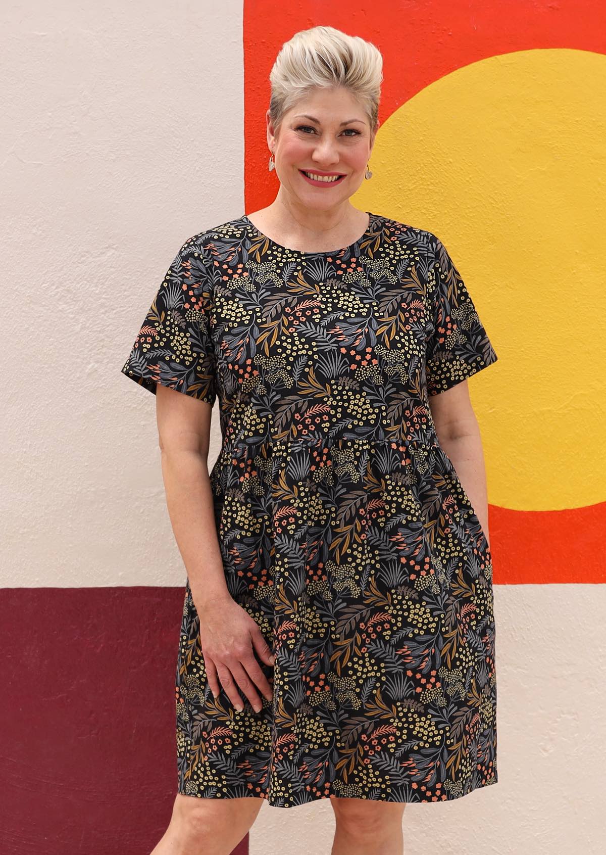 Botanical print on black base cotton dress with high round neckline and T-shirt sleeves and pockets