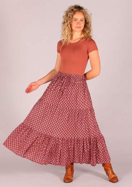 Model standing wearing 100 percent cotton three tiered maxi skirt in dark terracotta  