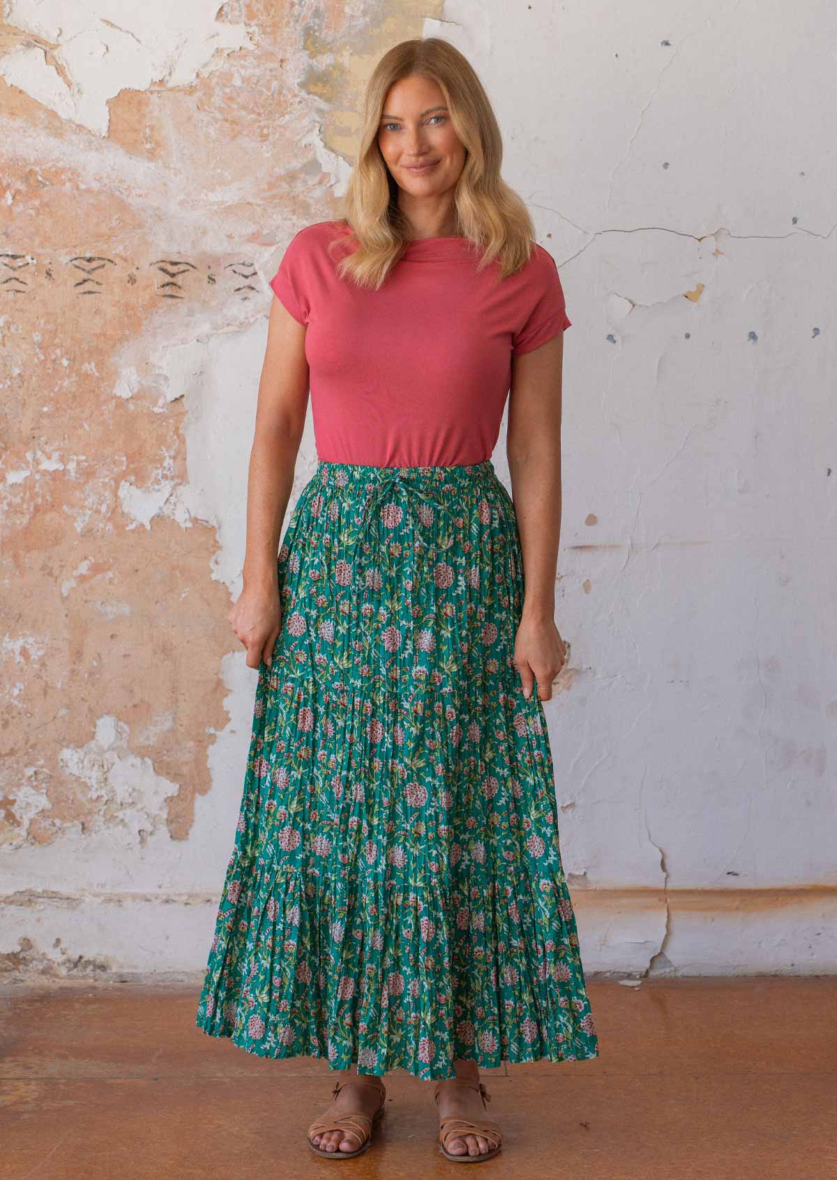 Woman wears 100% cotton maxi skirt with a drawstring in floral print on a jade green base