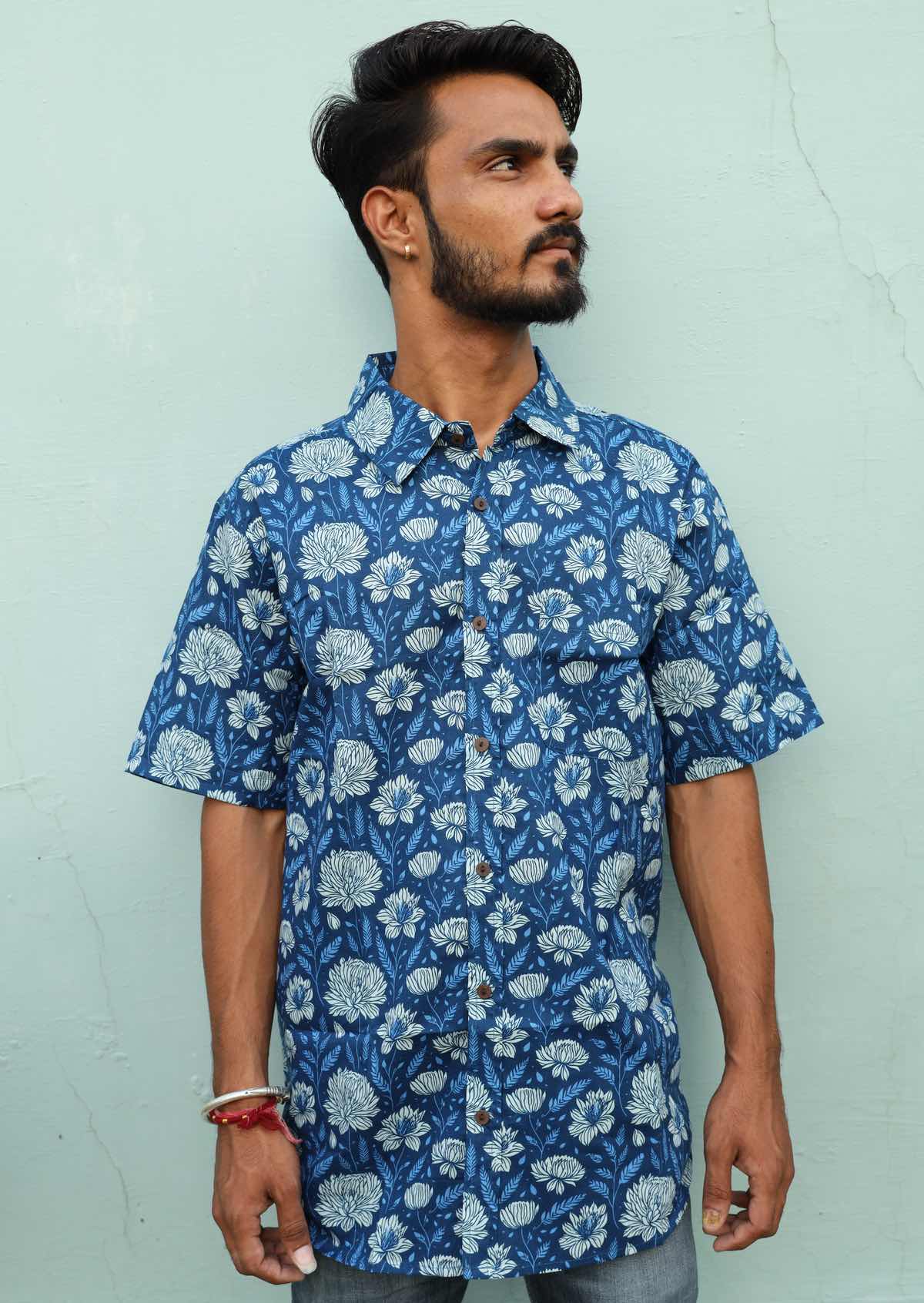 Man wearing blue floral cotton shirt with collar and coconut buttons and one pocket on left side