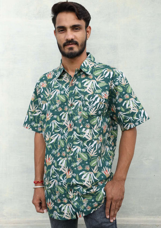 Man wearing relaxed fit cotton short sleeve shirt in earthy toned floral on dark green base