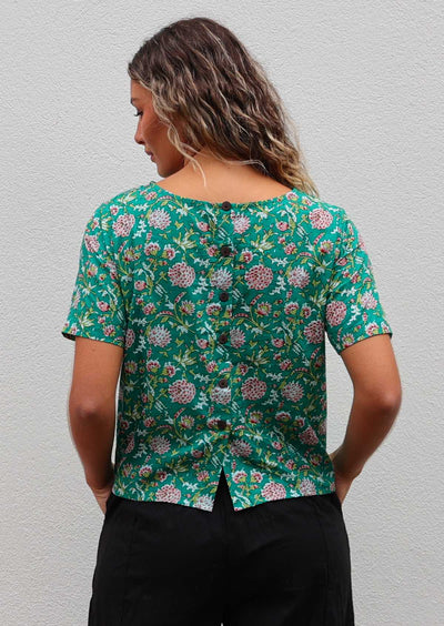Back of model in 100% cotton short sleeve top with decorative buttons down the centre of the back