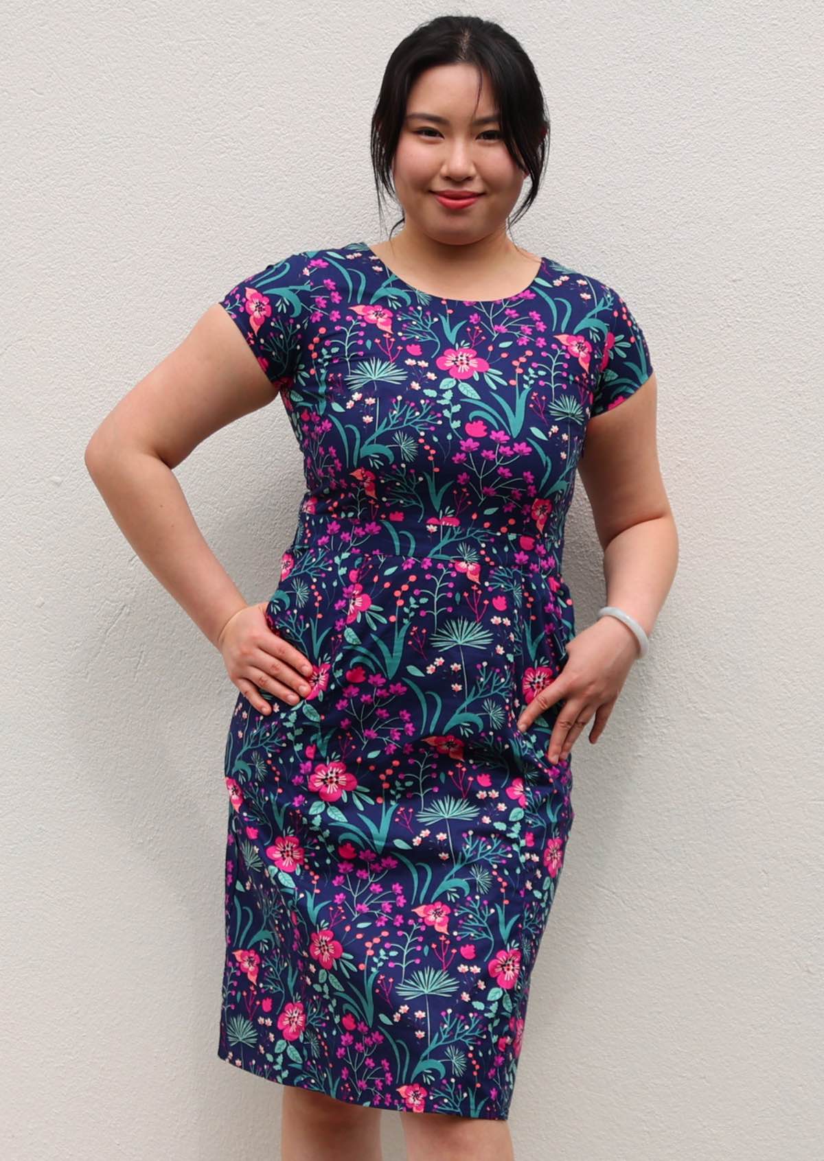 woman in navy and purple floral cotton knee length dress with round neckline empire waist