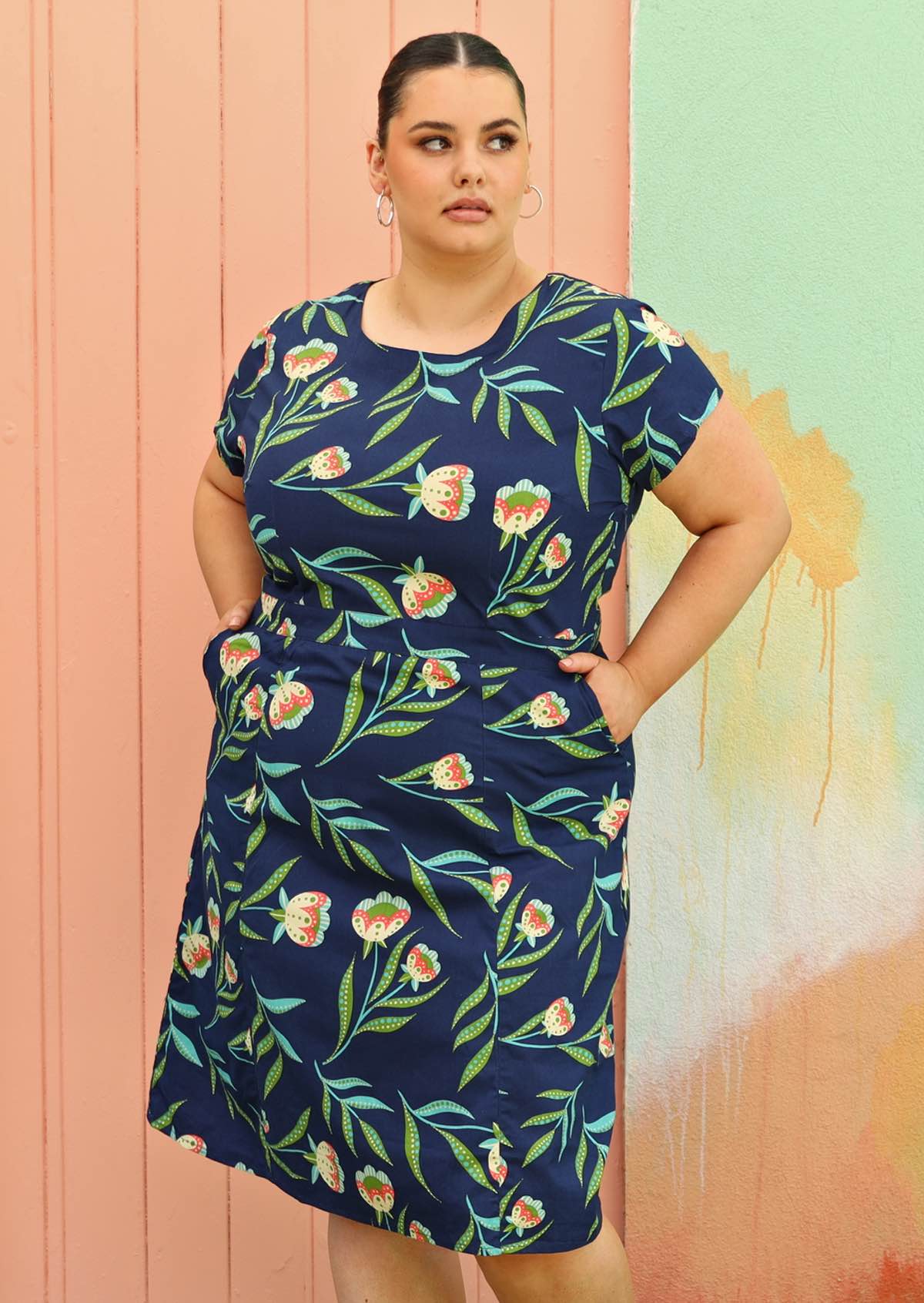 Plus size model wearing flattering cotton dress in navy blue