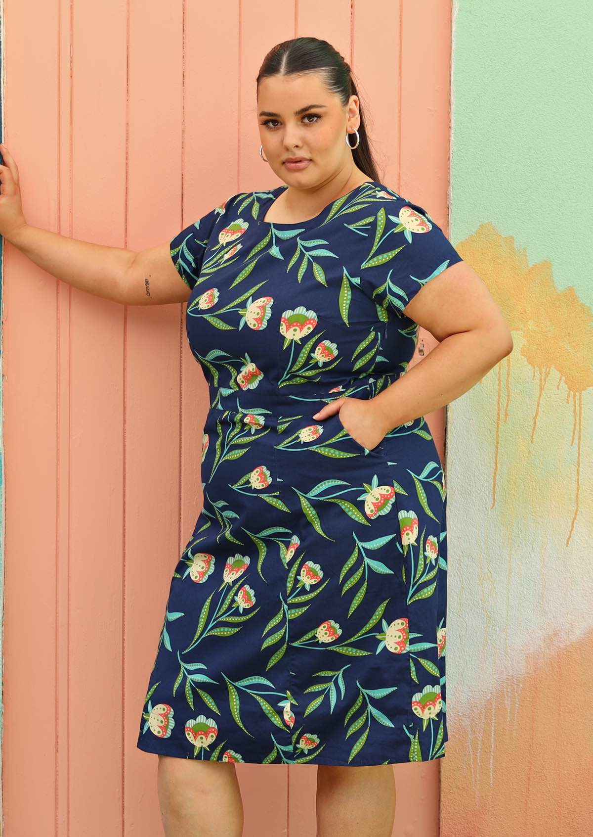 Plus size model wearing flattering cotton dress in navy blue below the knee