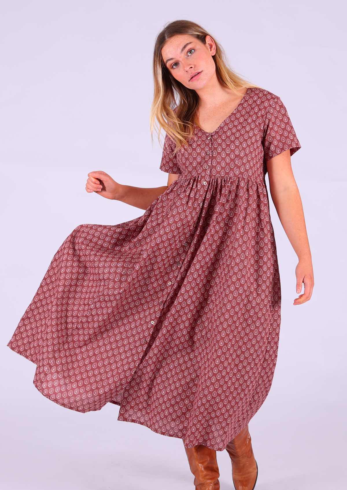 Woman modelling 100 percent cotton dark terracotta maxi sundress v-neck with pockets paired with tan leather boots 