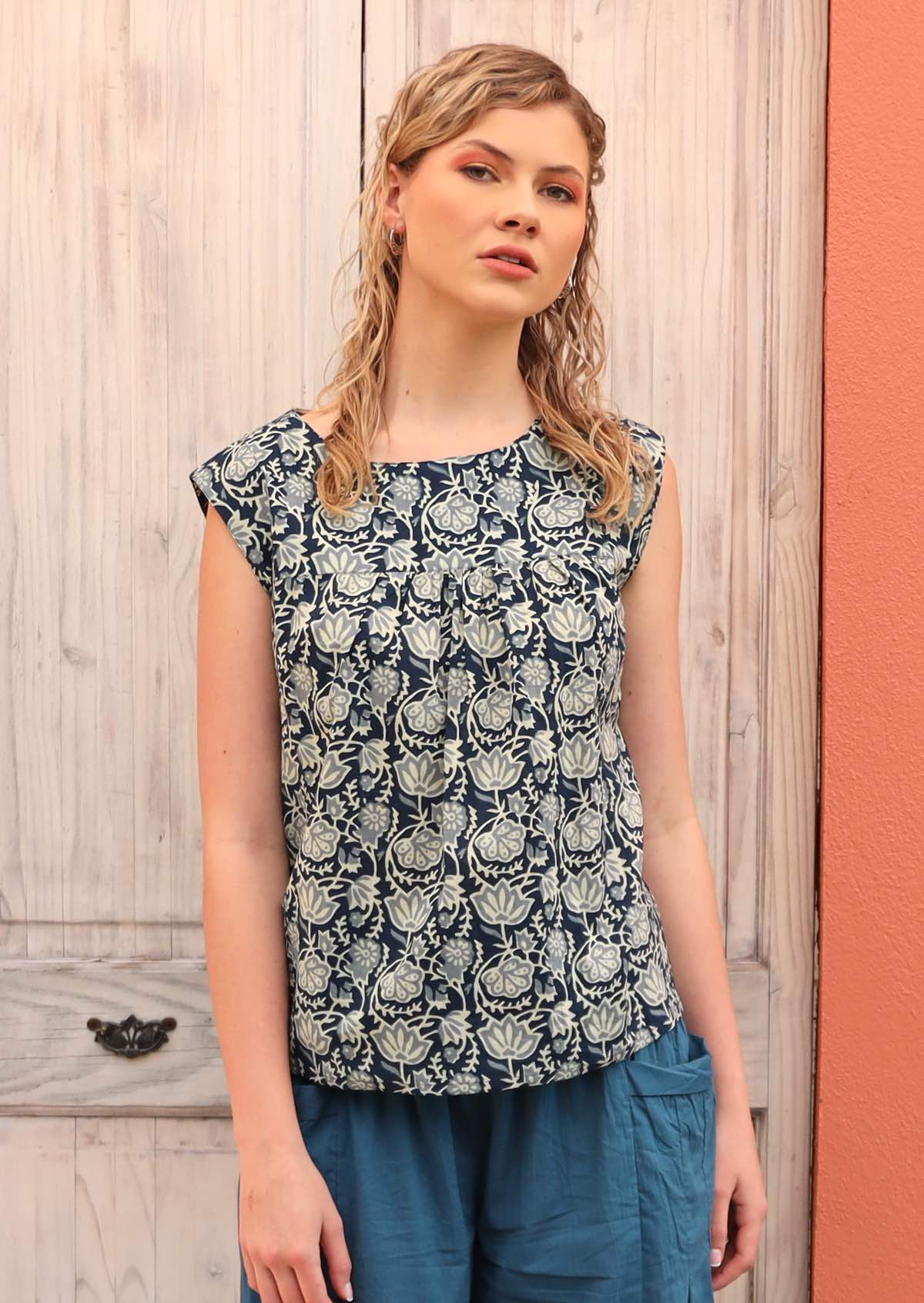 Woman styles a blue and white cotton top with blue pants. 