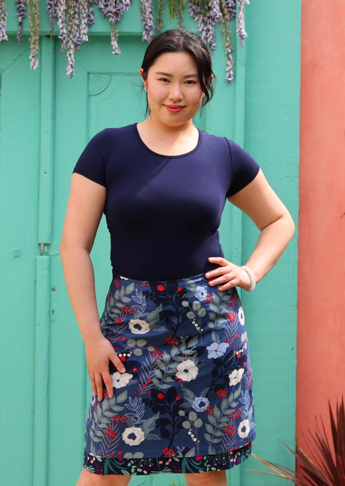 Model wearing bold blue floral print  reversible skirt 100 percent cotton knee length skirt. 