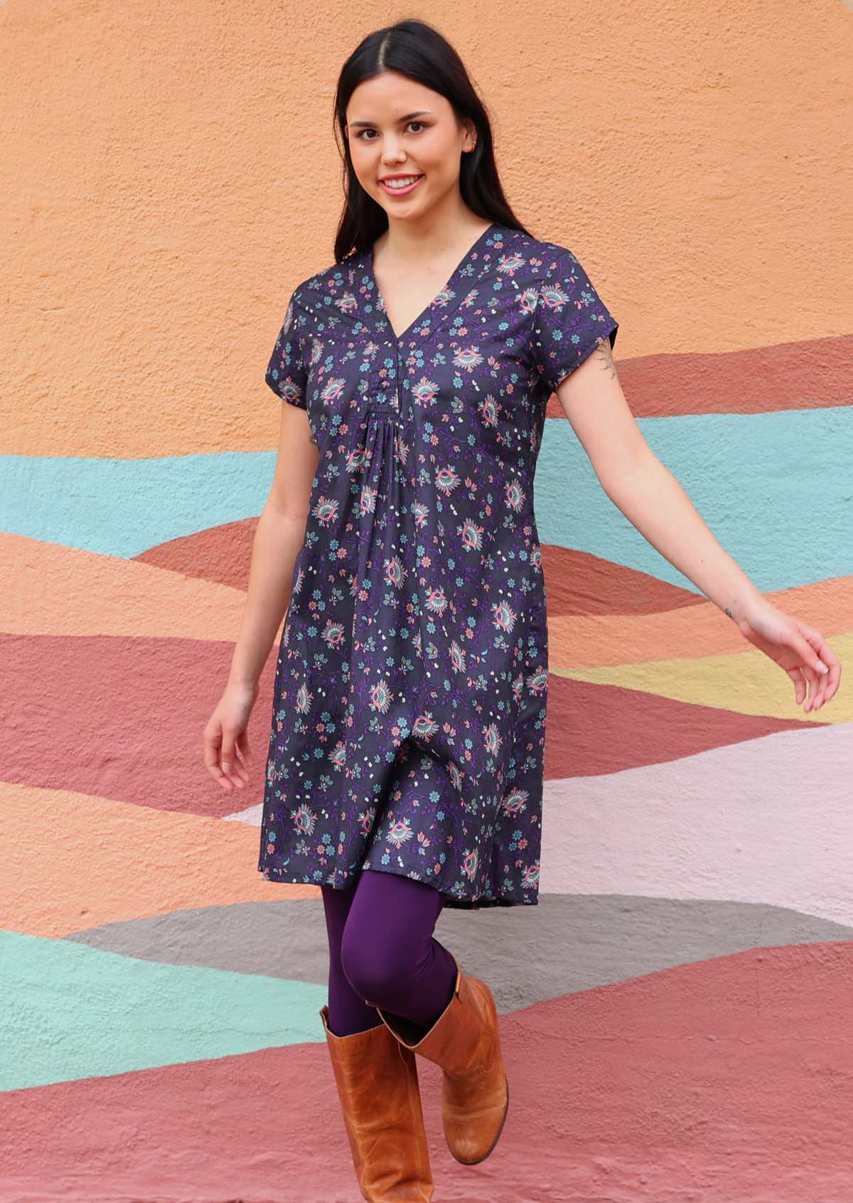 Model wearing short sleeve cotton dark purple tunic with dark purple leggings and tan leather boots