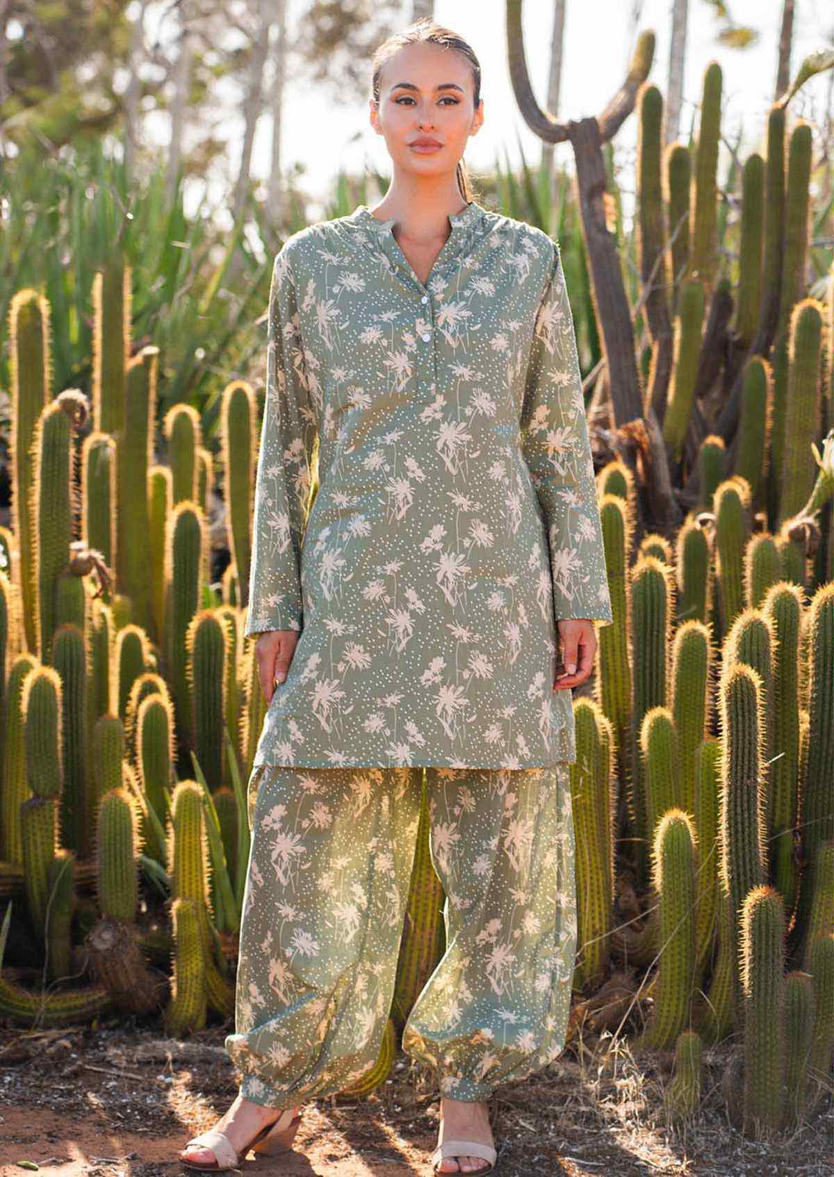 Woman wears cotton long sleeve tunic and pant combo in pale green with cream coloured florals