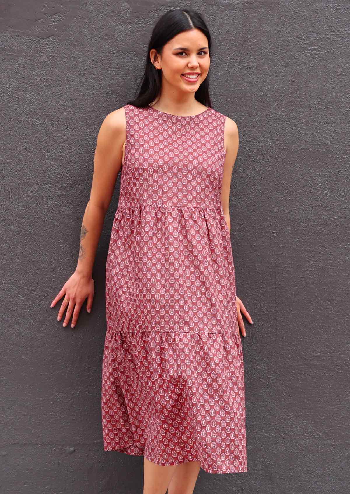 Woman with dark hair in Indian Cotton Sundress with three tiers in front of dark grey wall