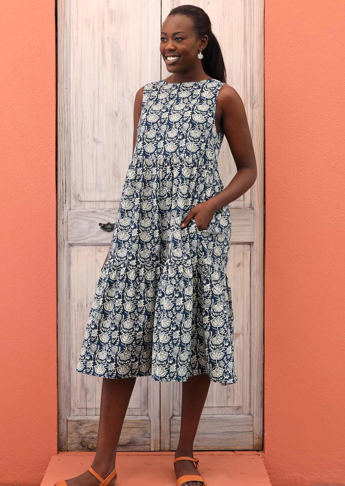 Smiling model wears 100% cotton, sleeveless dress. 