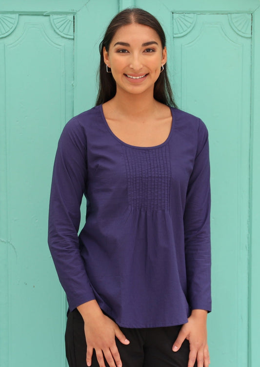 Model is wearing long sleeve dark blue cotton top with pintucks