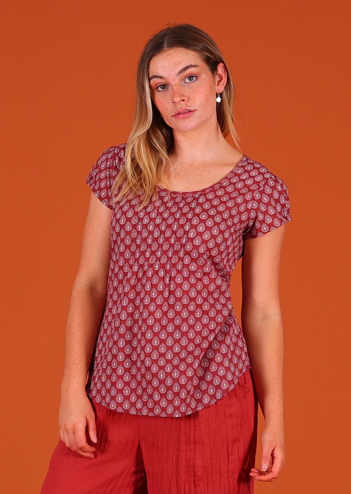 Model wearing 100 percent cotton Indian block print short sleeve pleated blouse dark terracotta