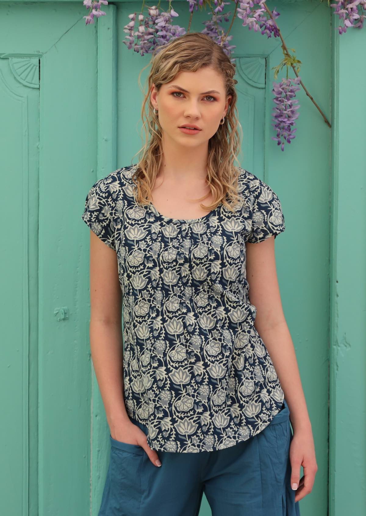 Model wears a top with small elastic trim in the sleeve. 