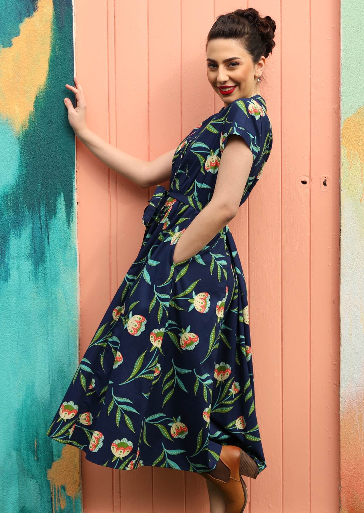 Model wears a long dress with pockets. 