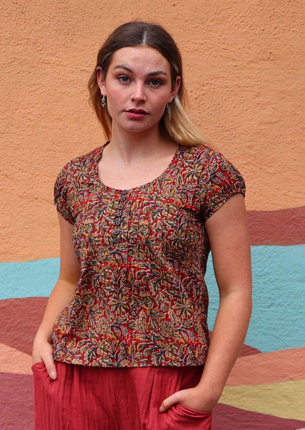 Model wearing 100 percent cotton Indian block print blouse on a red base with buttons