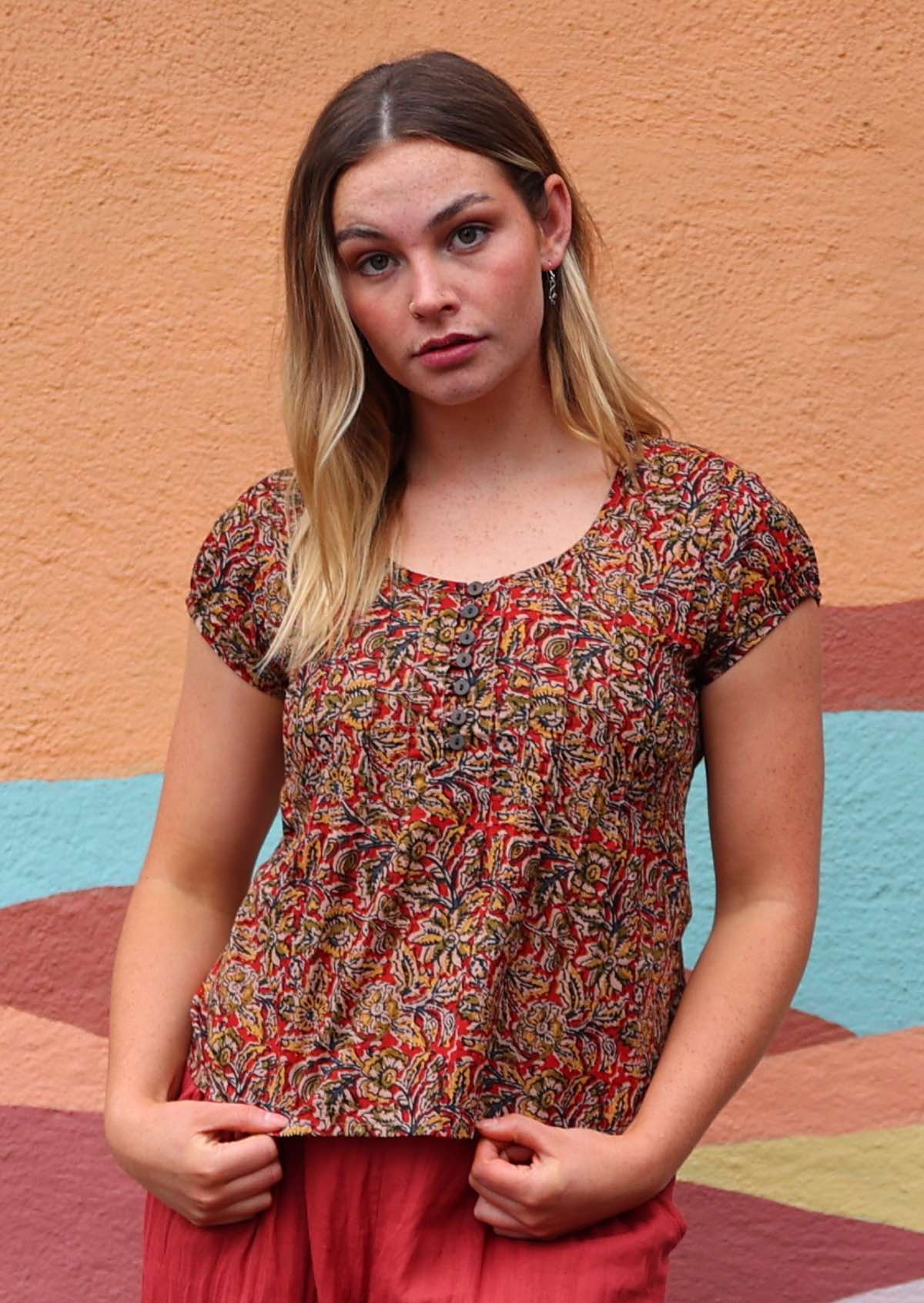 Model wearing 100 percent cotton Indian block print blouse florals on a red base with buttons