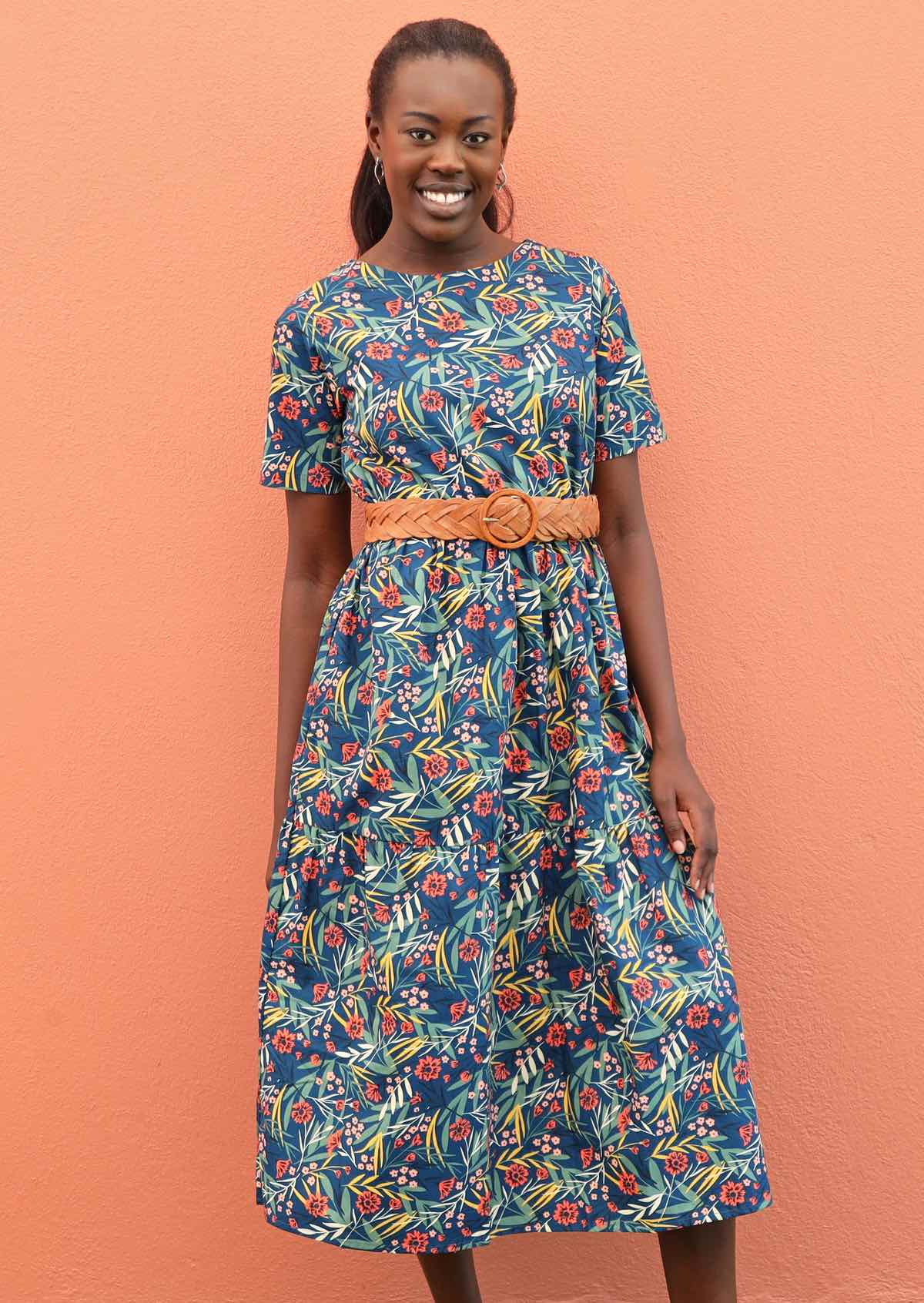 Model pairs relaxed fit dress with a belt around her waist. 